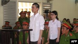 This picture taken on May 16, 2013 shows 21-year-old student Nguyen Phuong Uyen (2nd-R) and computer technician Dinh Nguyen Kha (C), 25, standing trial at a local People's Court in the southern province of Long An. 