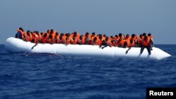 Des migrants arrivent près de la côte Libyenne abord d'un canoe gonflable, 3 aout 2015.