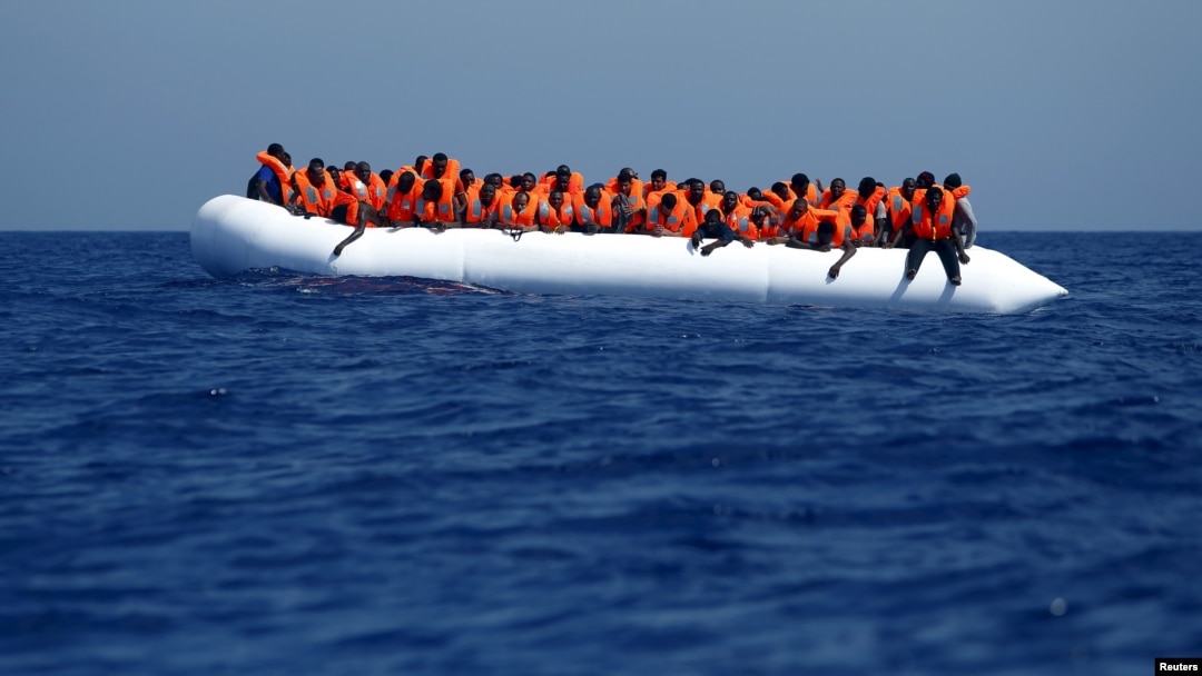 Para pengungsi di sebuah kapal tiup menunggu untuk dibantu Stasiun Bantuan Migran Lepas Pantai (MOAS) di Libya. (Foto: dok.)