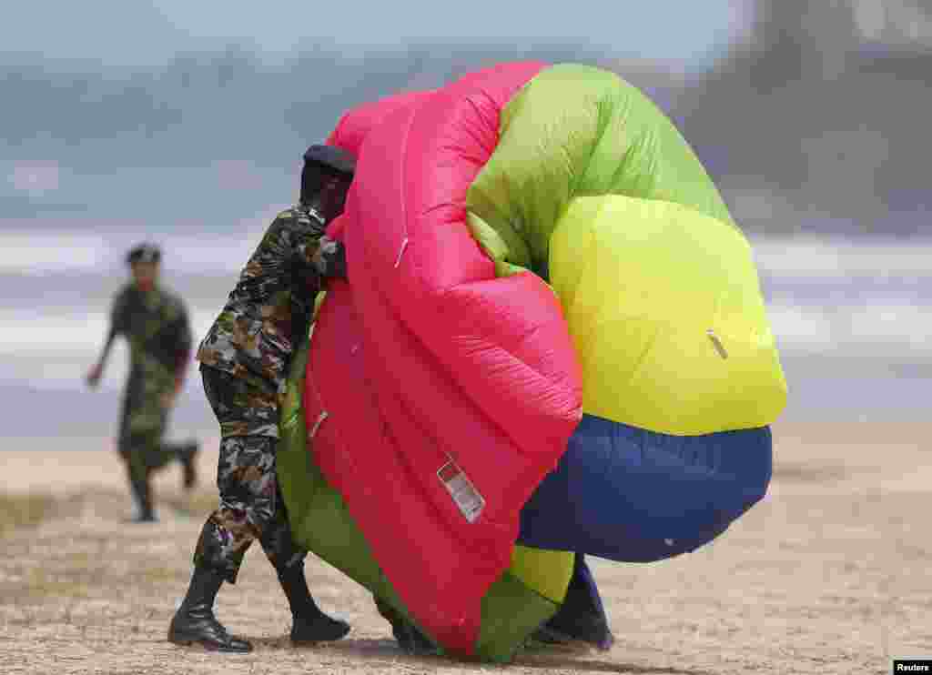 An air force officer assists a jumper with his parachute during a War Victory parade in Matara. Sri Lanka held a military parade and memorial for fallen soldiers to mark the fifth anniversary of the defeat of the Tamil Tigers, which ended a quarter-century civil war.