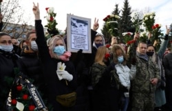 FILE - People gather outside a church during a memorial service for Roman Bondarenko, an anti-government protester who died in hospital following what witnesses said was a severe beating by security forces, in Minsk, Belarus, Nov. 20, 2020.