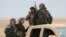FILE - Syrian Democratic Forces fighters ride on a vehicle near Raqqa, Feb. 5, 2017. The U.S.-backed troops have made significant advances.