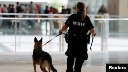 FILE - A San Diego Harbor Police K-9 officer patrols Lindbergh Field airport in San Diego, California, July 1, 2016. 