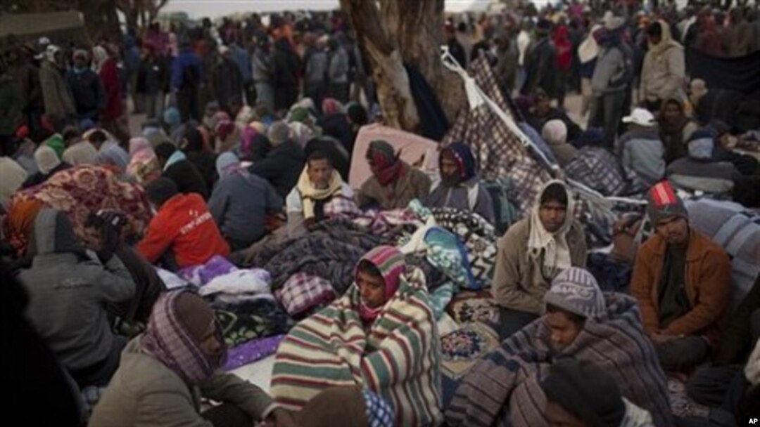 Men, who worked in Libya and fled the unrest in the country, wait for buses to be repatriated in a refugee camp at the Tunisia-Libyan border, in Ras Ajdir, Tunisia, March 10, 2011