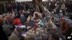 Men, who worked in Libya and fled the unrest in the country, wait for buses to be repatriated in a refugee camp at the Tunisia-Libyan border, in Ras Ajdir, Tunisia, March 10, 2011