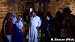 Des touristes posent devant le temple de Louxor, à Luxor, Egypte, le 9 septembre 2017. (H. Elrasam/VOA)