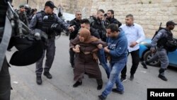 Israeli police officers scuffle with Palestinian protesters outside the Lions Gate to Jerusalem's Old City, March 12, 2019. 