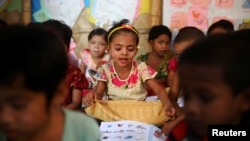 FILE - Rohingya refugee children attend a class to learn Burmese language at a refugee camp in Cox's Bazar, Bangladesh, April 9, 2019.