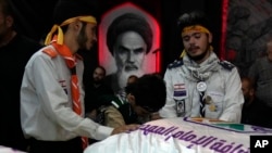 Members of Hezbollah's al-Mahdi scouts mourn over the coffins of Amira and Hassan Fadlallah, the children who were killed inside a building hit by an Israeli airstrike on Tuesday evening, during their funeral in a Beirut suburb, July 31, 2024.