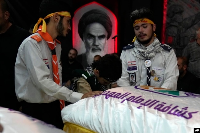 Members of Hezbollah's al-Mahdi scouts mourn over the coffins of Amira and Hassan Fadlallah, two children who were killed inside a building that was hit by an Israeli airstrike, during their funeral procession in a southern suburb of Beirut, Lebanon, on July 31, 2024.