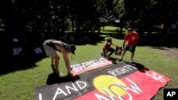 FILE - Protesters arrange signs in a social distanced crowd during an Aboriginal-lead Invasion Day rally on Australia Day in Sydney, Jan. 26, 2021. 