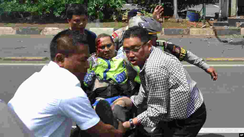 People carry an injured police officer near the site where an explosion went off in Jakarta.