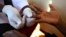 FILE - A doctor draws blood from a man to check for HIV/AIDS at a mobile testing unit in Ndeeba, a suburb in Uganda's capital Kampala. 