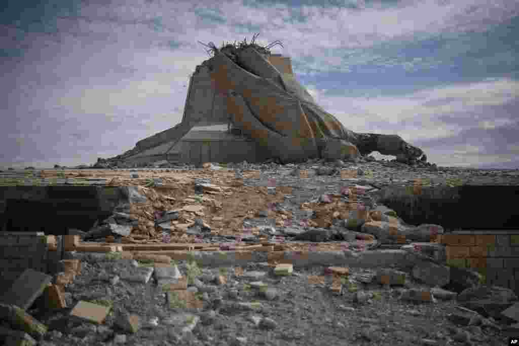 A statue depicting the late Syrian President Hafez Assad is seen destroyed on the top of a mount in Dayr Atiyah.