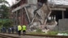 Policemen walk past a three-story building that collapsed in the South African town of Tongaat, about 28 miles north of Durban, Nov. 20, 2013.