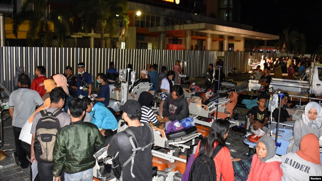 Para pasien di sebuah rumah sakit kota Mataram dievakuasi ke lapangan parkir setelah gempa kuat melanda Pulau Lombok, Minggu (5/8). 