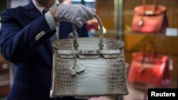 Seorang staf memegang tas 'Hermes diamond and Himalayan Nilo Crocodile Birkin' di kantor Heritage Auctions di Beverly Hills, California, 22 September 2014.