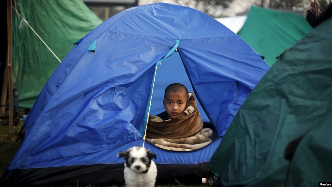 A boy sits inside a tent on an open ground, after Saturday's earthquake in Kathmandu, Nepal early April 29, 2015.