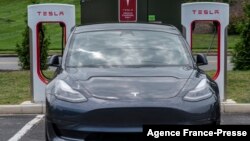 Sebuah mobil Tesla mengisi baterai di stasiun pengisian baterai listrik di Arlington, Virginia, AS (foto: ilustrasi).