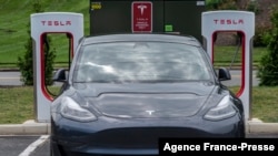 Foto yang diambil pada 13 Agustus 2021 ini, menunjukkan mobil listrik yang tengah mengisi daya di stasiun pengisian daya milik Tesla di Arlington, Virginia. (Foto: AFP/Andrew Caballero-Reynolds)