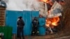 En esta foto divulgada por el gobernador de la región de Belgorod, en Rusia, se observa a trabajadores de emergencia junto a una casa incendiada después de un bombardeo ucraniano el 17 de marzo de 2024.