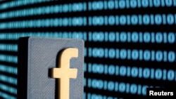 A 3-D printed Facebook logo is seen in front of displayed binary code in this illustratin, June 18, 2019. (REUTERS/Dado Ruvic/Illustration/File Photo)