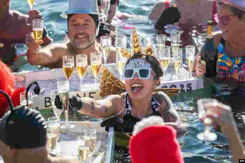 Revelers take part in a New Year&#39;s day swim in Lake Geneva with its 7.3 degree celsius waters in Geneva, Switzerland.