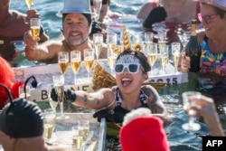 Revelers take part in a New Year's day swim in Lake Geneva with its 7.3 degree celsius waters in Geneva, Switzerland, Jan. 1, 2025.