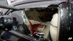 A Pakistani cameraman films the blood-stained damaged car of slain Pakistan's government minister for religious minorities Shahbaz Bhatti in Islamabad, Pakistan, March 2, 2011.