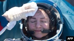 FILE - NASA astronaut Jessica Meir rests after landing in a remote area outside of Dzhezkazgan, Kazakhstan, April 17, 2020. Two NASA astronauts and a Russian cosmonaut had been aboard the International Space Station.