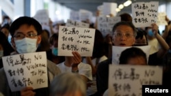 示威者6月13日在香港立法会外手持标语抗议