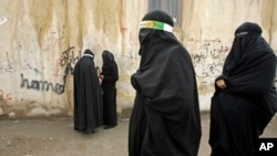 FILE - Veiled Iranian women take part in a mourning ceremony, as they cover their faces symbolically, in the city of Khorramabad, southwest of Tehran.