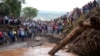 People gather on a bridge where a woman's body was retrieved after floodwater washed away houses and people in Kamuchiri village, Nakuru county, Kenya, on April 30, 2024. At least 48 people were killed in the incident.