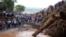 People gather on a bridge where a woman's body was retrieved after floodwater washed away houses and people in Kamuchiri village, Nakuru county, Kenya, on April 30, 2024. At least 48 people were killed in the incident.