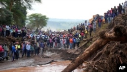 FILE—People gather on a bridge where a woman's body was retrieved, after floodwater washed away houses, in Kamuchiri Village Mai Mahiu, Nakuru County, Kenya, April 30, 2024.