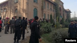 Policiers et secouristes devant l'Institut de formation agricole de Peshawar, Pakistan, le 1er décembre 2017. 