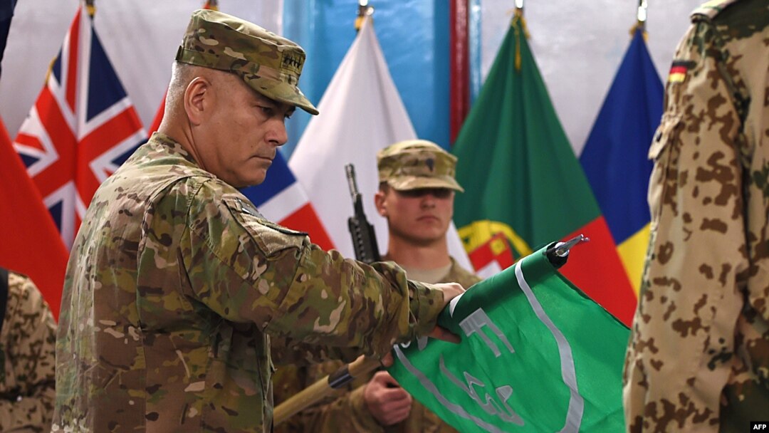 Jenderal AS John Campbell (kiri) menggulung bender ISAF yang dipimpin oleh NATO dalam upacara yang menandai berakhirnya misi ISAF di Afghanistan di markas besar ISAF di Kabul, 28 Desember 2014. 
