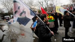 FILE - Demonstrators wave flags with the image of imprisoned Kurdish rebel leader Abdullah Ocalan during a rally in Istanbul, Feb. 15, 2015. Ocalan called on followers to agree to lay down their arms.