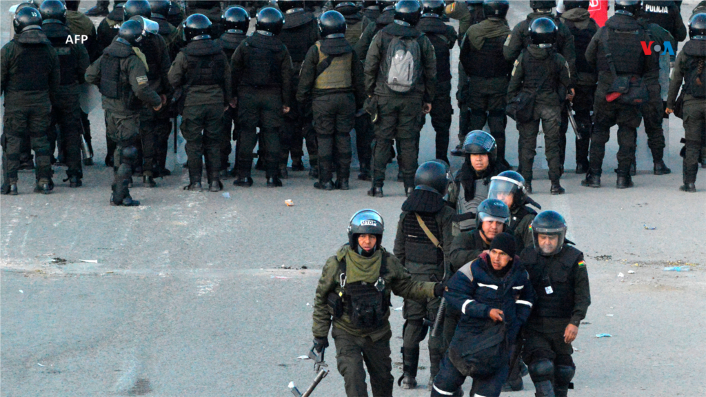 La policía antidisturbios detiene a un hombre después de despejar un bloqueo de carreteras por parte de manifestantes que apoyaban alex presidente Evo Morales.