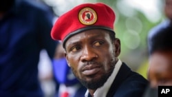 FILE - Opposition presidential candidate Bobi Wine speaks to the media outside his home, in Magere, near Kampala, Uganda, Jan. 26, 2021. 