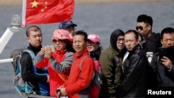中国游客在靠近辽宁丹东市的鸭绿江上乘船观光。（2017年4月2日）