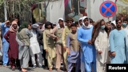 Los afganos hacen fila frente a un banco para sacar su dinero después de la toma del poder por los talibanes en Kabul, Afganistán, el 1 de septiembre de 2021.