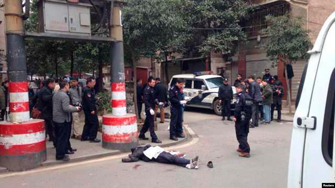 A body is pictured lying on the ground at a crime scene on a street, in Changsha, Hunan Province March 14, 2014. 
