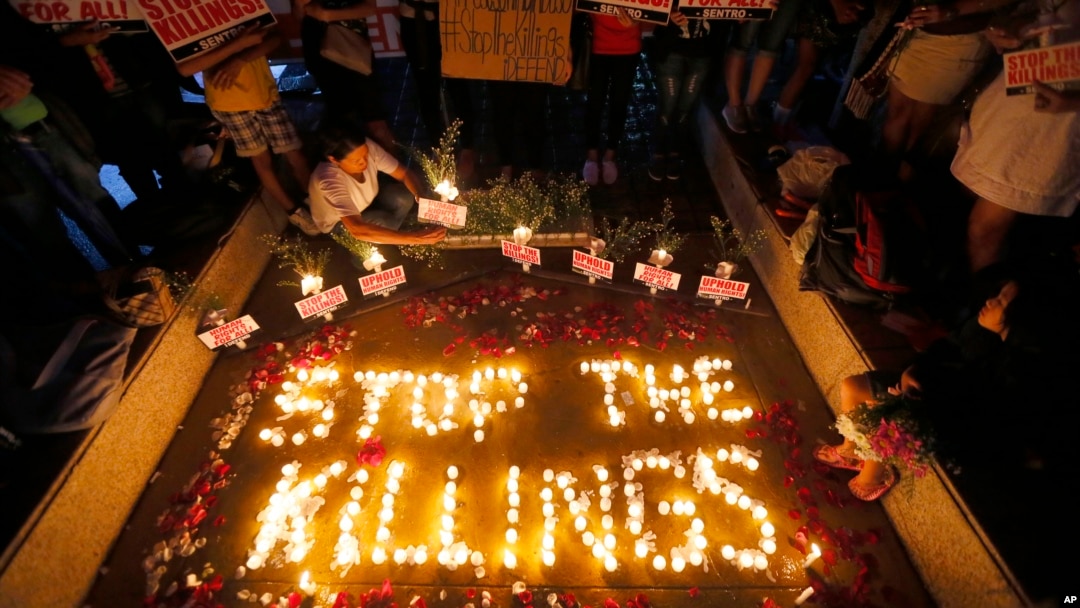 FILE - human rights activists light candles for the victims of extra-judicial killings around the country in the wake of "War on Drugs" campaign by Philippine President Rodrigo Duterte in suburban Quezon city northeast of Manila, Philippines. 