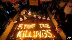 FILE - human rights activists light candles for the victims of extra-judicial killings around the country in the wake of "War on Drugs" campaign by Philippine President Rodrigo Duterte in suburban Quezon city northeast of Manila, Philippines. 