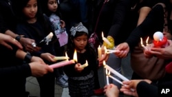 A girl among people during a vigil, outside of the presidential palace in Nicosia, Cyprus, April 26, 2019. 