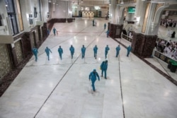 Cleaners wear protective face masks, following the outbreak of the coronavirus, as they swipe the floor at the Grand mosque in the holy city of Mecca, Saudi Arabia, March 3, 2020.