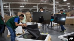 FILE - Workers check screens for faults at an LG flat screen TV assembly plant in Reynosa, Mexico, across the border from McAllen, Texas, March 23, 2017. On Jan. 5, 2019, it was announced that Mexican business and labor leaders had agreed to double the mi