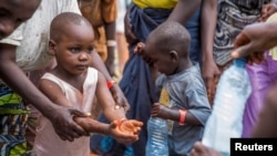 FILE - A refugee boy from Burundi who fled violence and political tension washes his hands at the Nyarugusu refugee camp in western Tanzania.