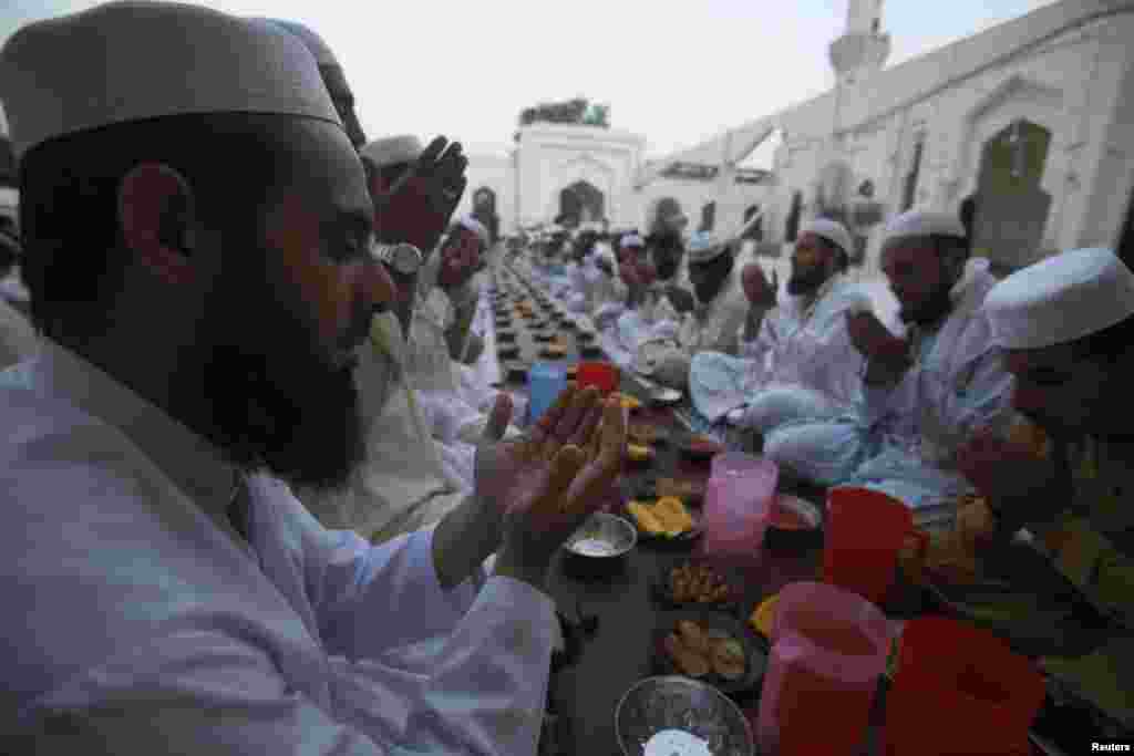 Para pria berdoa sebelum berbuka puasa dalam hari pertama Ramadan di sebuah masjid di Peshawar (29/6). (Reuters/Fayaz Aziz)